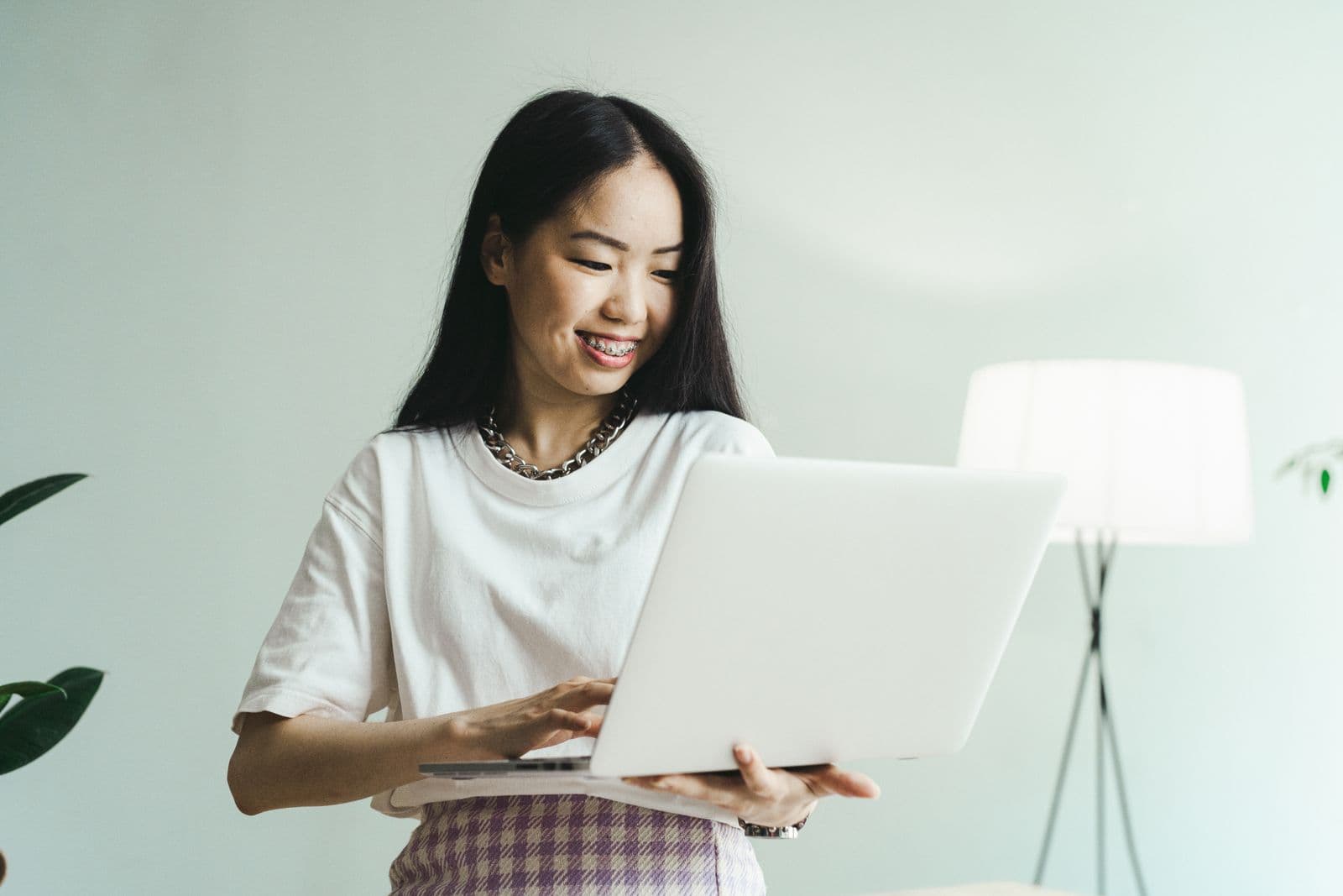Business owner smiling while checking her sales on a laptop
